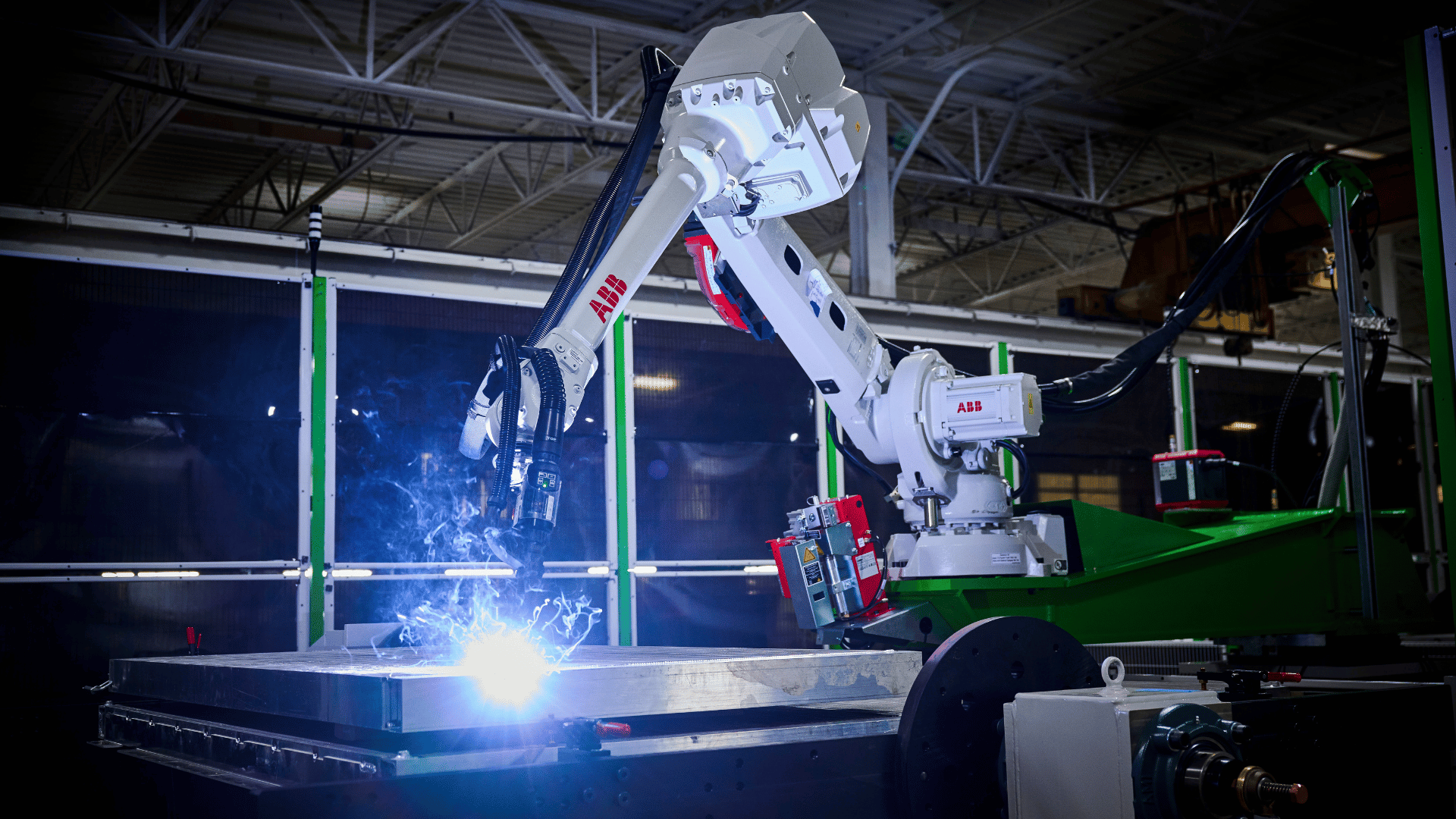 BB IRB 4600 industrial welding robot mounted on a seventh-axis rotating base between two welding stations.