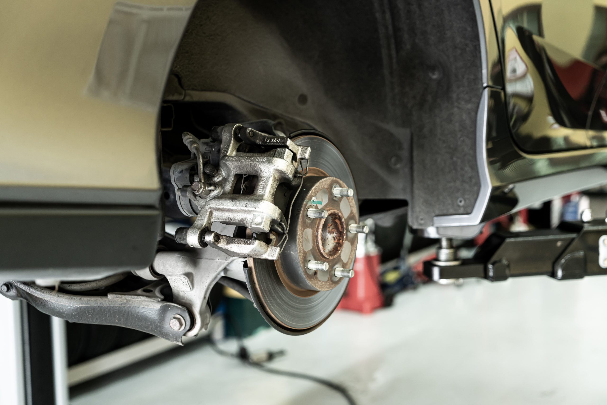 Disc car close up – mechanic unscrewing automobile parts while w Disc car close up - mechanic unscrewing automobile parts while working under a lifted auto - Car service concept